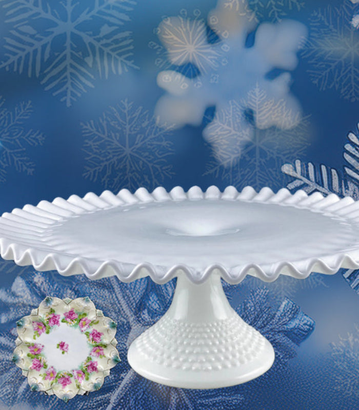 Set of white cake stands and platters on a blue background with snowflake designs