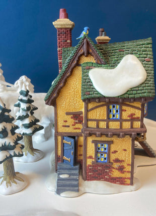 Illuminated Porcelain Christmas Village "Wingham Lane Parrot Seller" House" by Dept 56. and Woman Holding Bird Cage, Dickens Village, 1999.