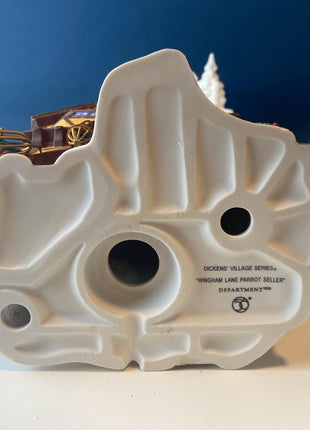 Illuminated Porcelain Christmas Village "Wingham Lane Parrot Seller" House" by Dept 56. and Woman Holding Bird Cage, Dickens Village, 1999.