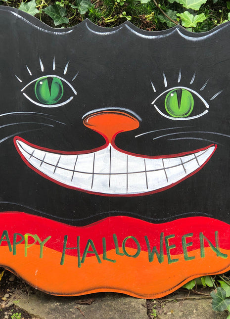 Sign on Wooden Black Cat Cutout Reading Happy Halloween.